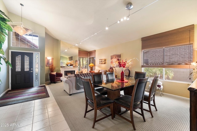 tiled dining space featuring high vaulted ceiling