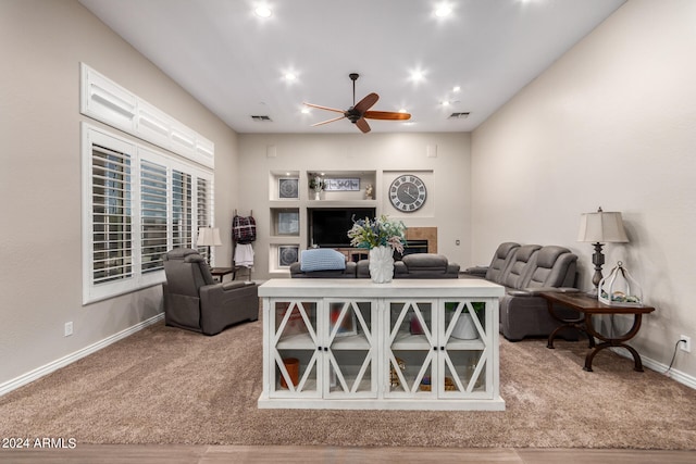 living room with hardwood / wood-style flooring, ceiling fan, and a tile fireplace