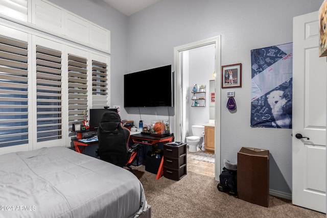 bedroom with ensuite bath and light colored carpet