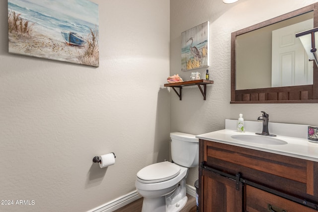 bathroom featuring wood-type flooring, vanity, and toilet