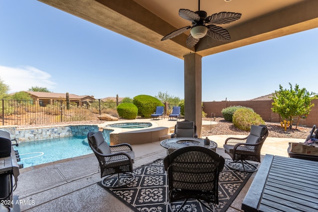 view of patio with ceiling fan, a swimming pool with hot tub, and an outdoor living space with a fire pit