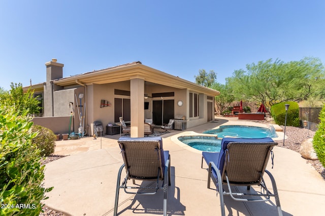 view of pool with ceiling fan, an in ground hot tub, and a patio