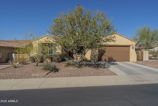 view of front of house featuring a garage, a tile roof, concrete driveway, and stucco siding