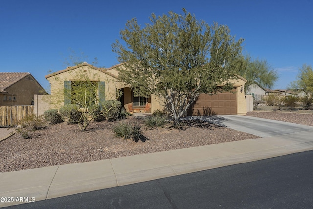 view of front facade with concrete driveway, an attached garage, fence, and stucco siding