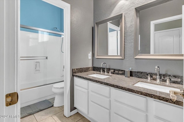 full bathroom featuring combined bath / shower with glass door, vanity, tile patterned floors, and toilet