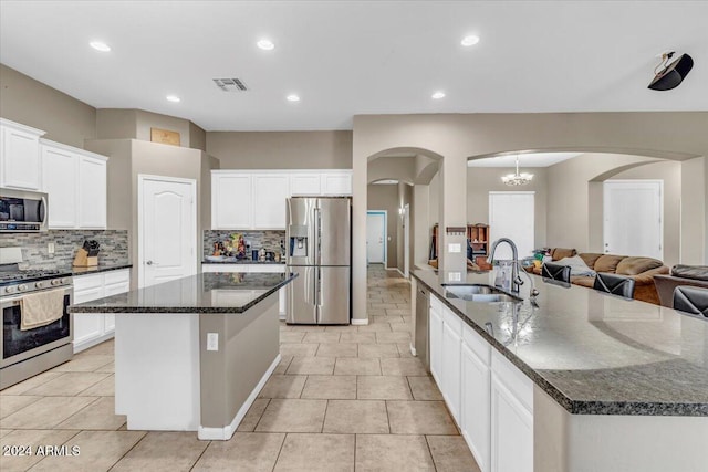 kitchen with a spacious island, decorative backsplash, sink, and stainless steel appliances