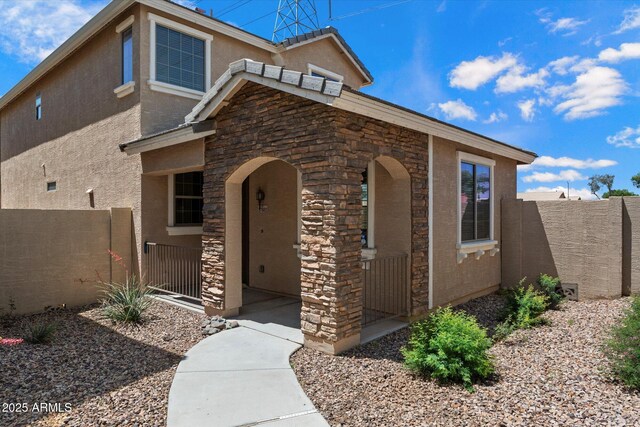 17802 N 114th Ln, Surprise, AZ 85378 - view of front of property featuring stone siding, stucco siding, fence, and a porch