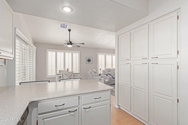 kitchen with white cabinetry, ceiling fan, a textured ceiling, and light wood-type flooring