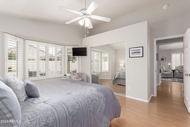 bedroom with vaulted ceiling, light hardwood / wood-style flooring, and ceiling fan