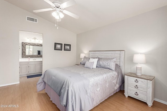 bedroom with ensuite bath, ceiling fan, sink, light hardwood / wood-style floors, and lofted ceiling