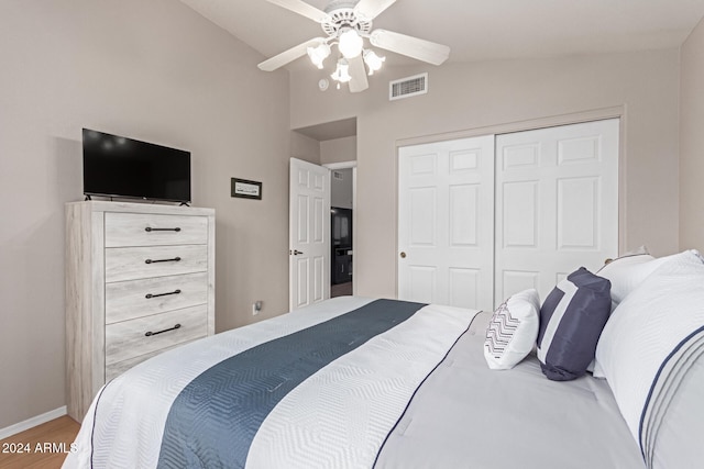 bedroom featuring light hardwood / wood-style flooring, vaulted ceiling, a closet, and ceiling fan