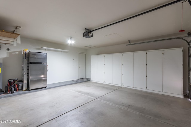 garage featuring stainless steel fridge and a garage door opener