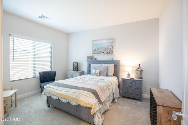 bedroom with baseboards, visible vents, and light colored carpet