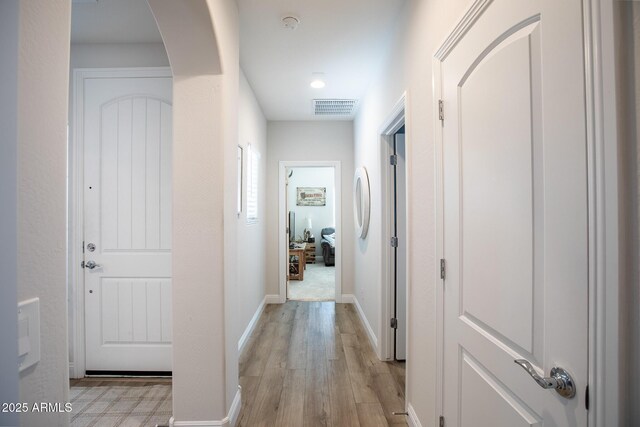 6460 W Springfield Way, Florence, AZ 85132 - hallway featuring arched walkways, baseboards, visible vents, and light wood finished floors