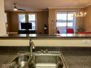 kitchen with ornamental molding, pendant lighting, sink, and a wealth of natural light