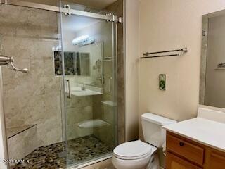 bathroom with vanity, an enclosed shower, and toilet