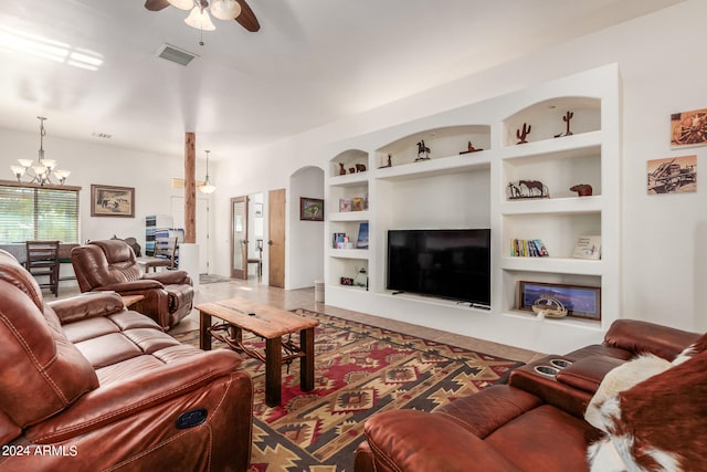 living room with built in features and ceiling fan with notable chandelier