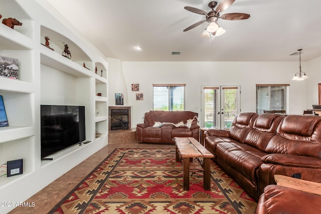 tiled living room with built in shelves and ceiling fan with notable chandelier