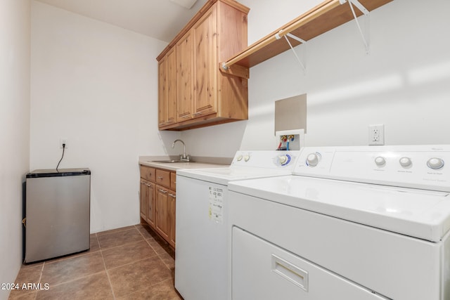 clothes washing area featuring tile flooring, cabinets, sink, and washer and dryer