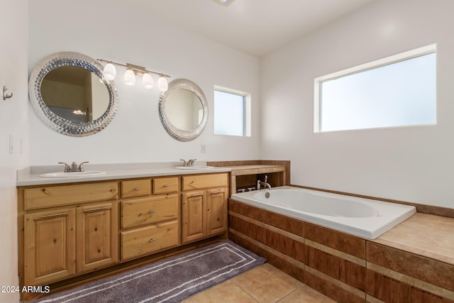 bathroom featuring oversized vanity, a relaxing tiled bath, tile floors, and dual sinks