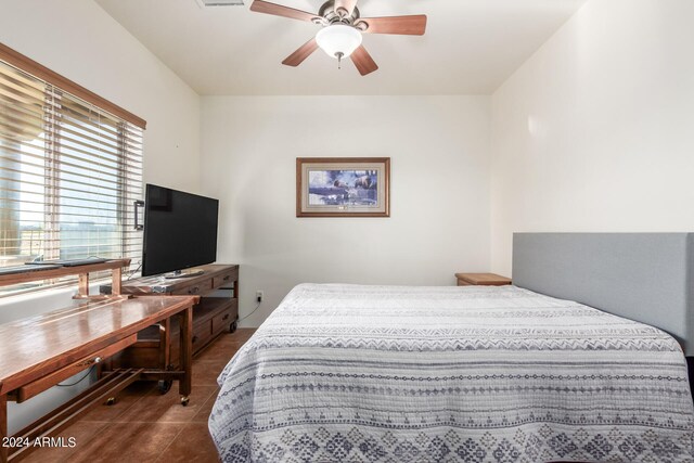 bedroom with ceiling fan and dark tile floors