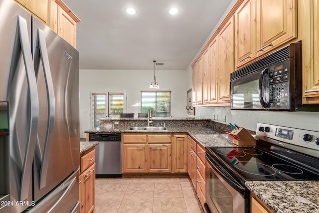 kitchen with stone counters, hanging light fixtures, stainless steel appliances, sink, and light tile floors