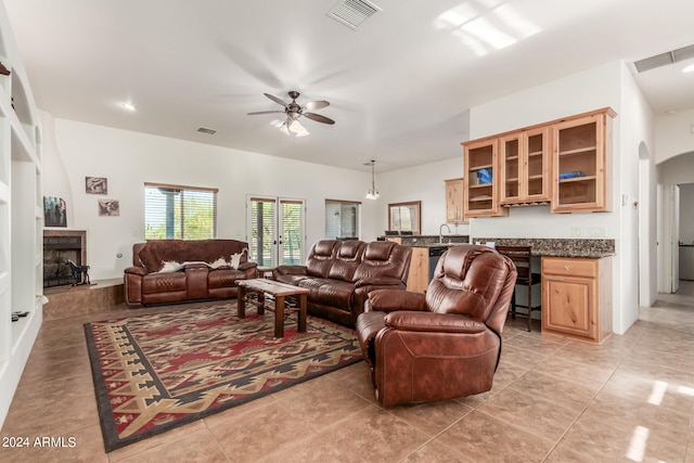 living room featuring sink, ceiling fan, and light tile floors