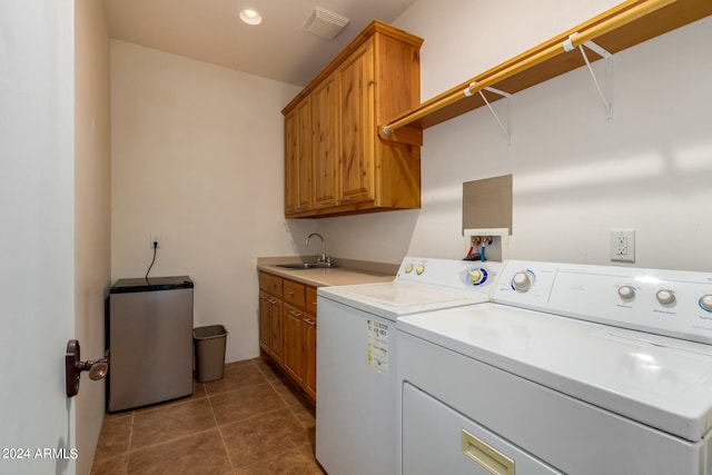 washroom featuring washer and clothes dryer, dark tile flooring, cabinets, and sink