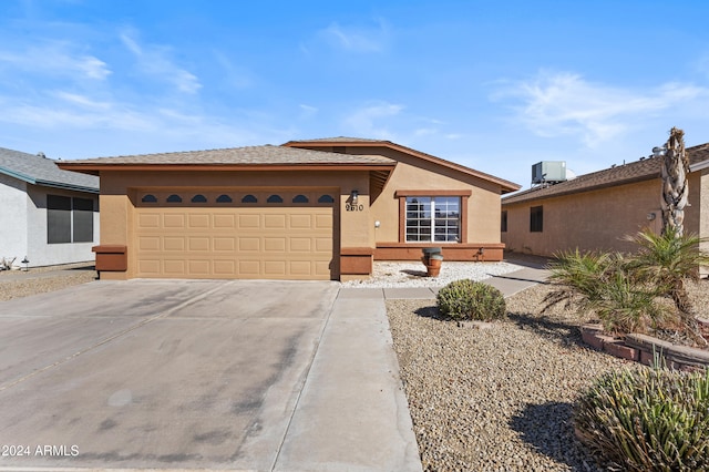 view of front of property featuring central AC and a garage