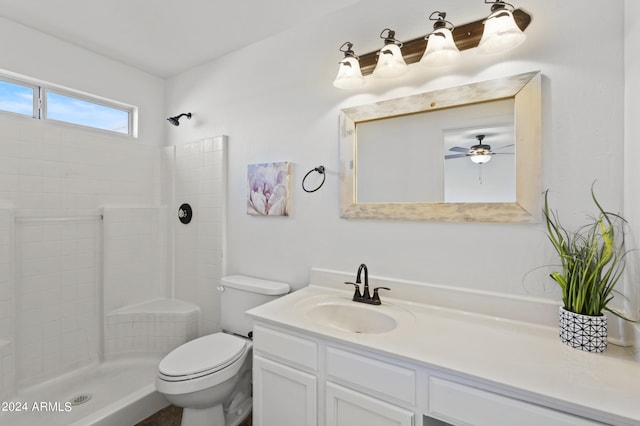 bathroom featuring toilet, walk in shower, vanity, and ceiling fan