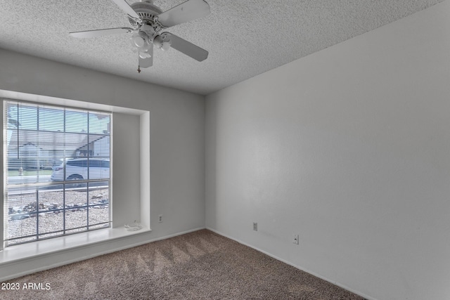 carpeted empty room featuring ceiling fan and a textured ceiling