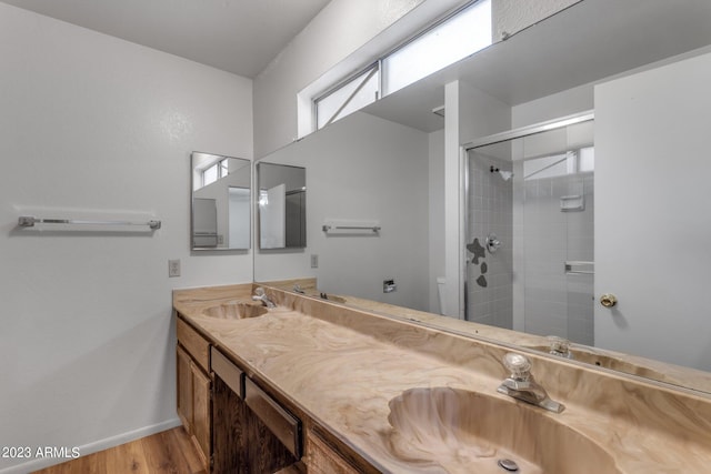 bathroom with toilet, vanity, a shower with shower door, and hardwood / wood-style flooring