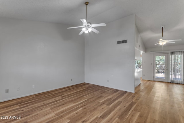 unfurnished living room with ceiling fan, vaulted ceiling, and light hardwood / wood-style flooring