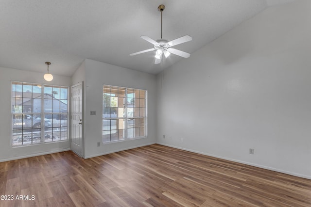 empty room featuring ceiling fan, hardwood / wood-style floors, and vaulted ceiling