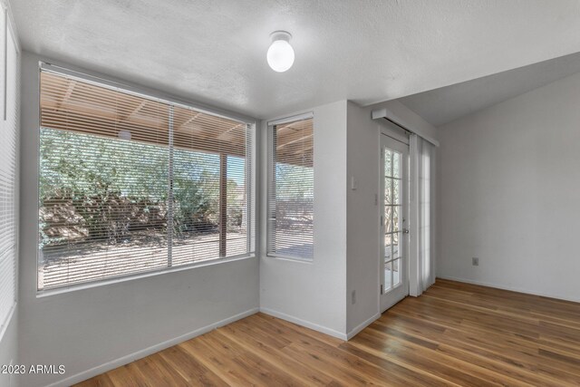 spare room with hardwood / wood-style floors and a textured ceiling