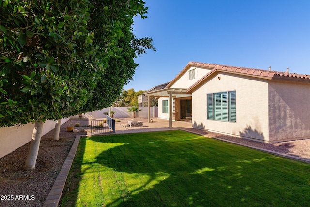 rear view of property featuring an outdoor fire pit, a patio area, and a yard