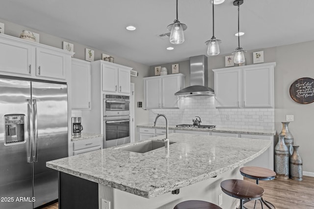 4246 Stage Stop Way, Wickenburg, AZ 85390 - kitchen featuring appliances with stainless steel finishes, wall chimney exhaust hood, a sink, wood finished floors, and tasteful backsplash