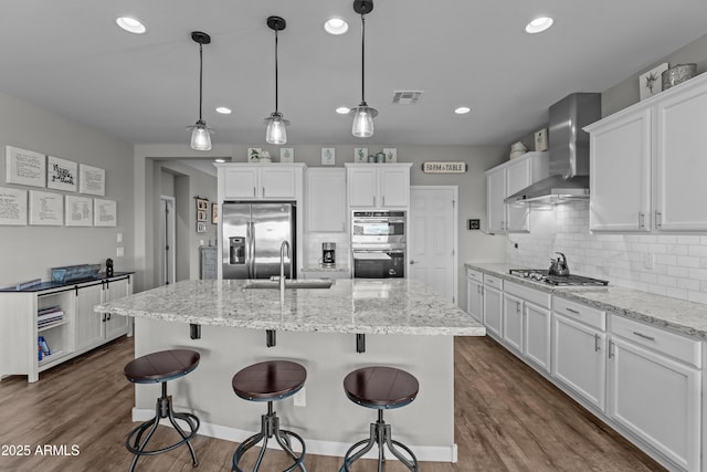 4246 Stage Stop Way, Wickenburg, AZ 85390 - kitchen featuring stainless steel appliances, wall chimney range hood, a sink, white cabinets, and tasteful backsplash