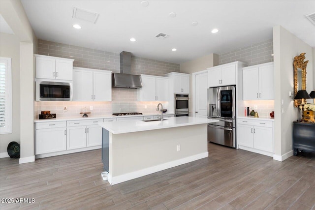 kitchen featuring white cabinetry, built in microwave, sink, gas stovetop, and stainless steel fridge