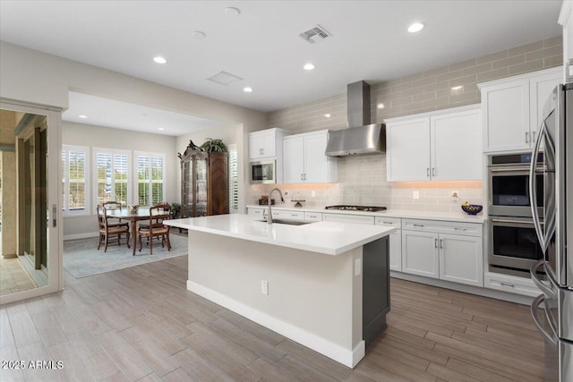 kitchen with white cabinetry, a kitchen island with sink, and sink