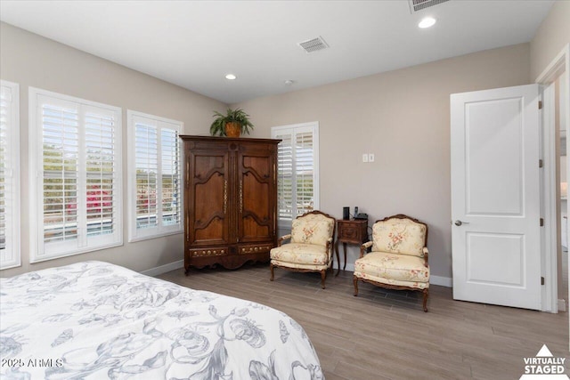 bedroom with light hardwood / wood-style floors and multiple windows