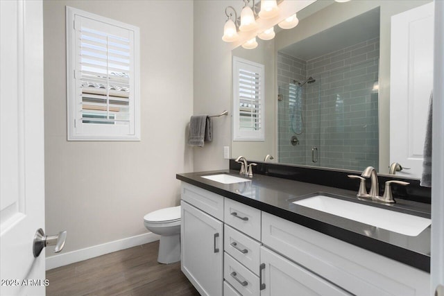 bathroom with hardwood / wood-style flooring, vanity, walk in shower, and a wealth of natural light