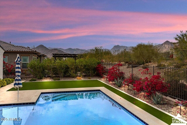 pool at dusk featuring a mountain view