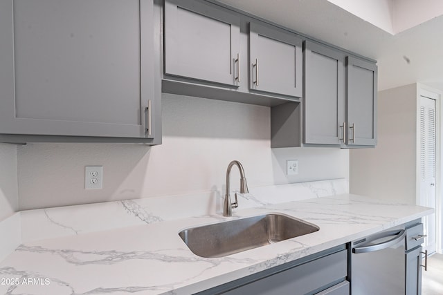 2440 N 22nd Ave, Phoenix, AZ 85009 - kitchen with gray cabinetry, a sink, stainless steel dishwasher, and light stone countertops