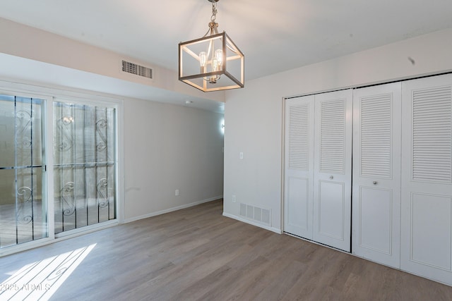 2440 N 22nd Ave, Phoenix, AZ 85009 - unfurnished dining area featuring wood finished floors, a chandelier, and baseboards