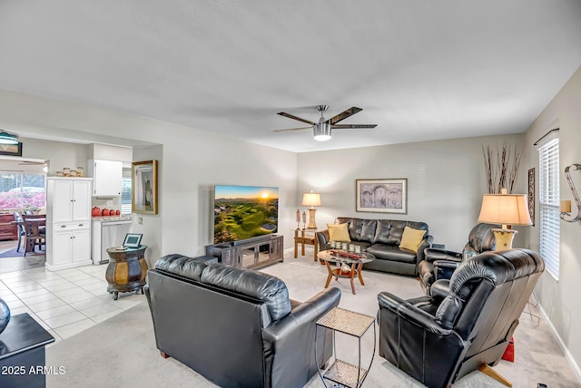 living area with ceiling fan, light tile patterned flooring, and baseboards
