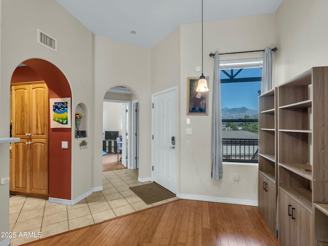 1401 N 4th St Unit 234, Flagstaff, AZ 86004 - foyer entrance with arched walkways, light wood finished floors, a towering ceiling, and a mountain view