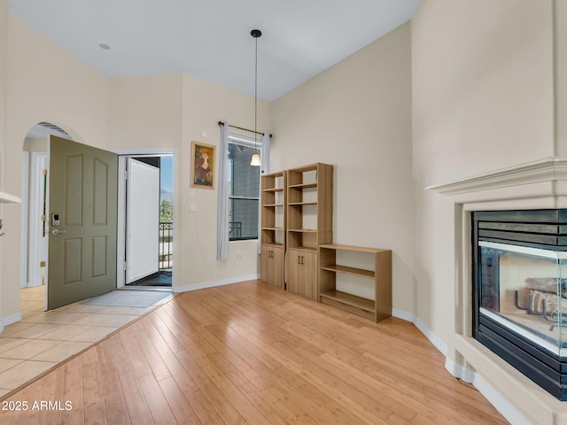 1401 N 4th St Unit 234, Flagstaff, AZ 86004 - entryway featuring light wood-style floors, arched walkways, a multi sided fireplace, and a towering ceiling