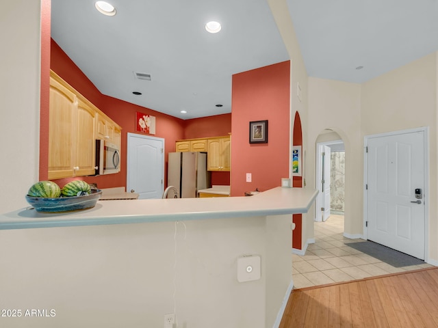 1401 N 4th St Unit 234, Flagstaff, AZ 86004 - kitchen with stainless steel appliances, arched walkways, a peninsula, light brown cabinetry, and recessed lighting