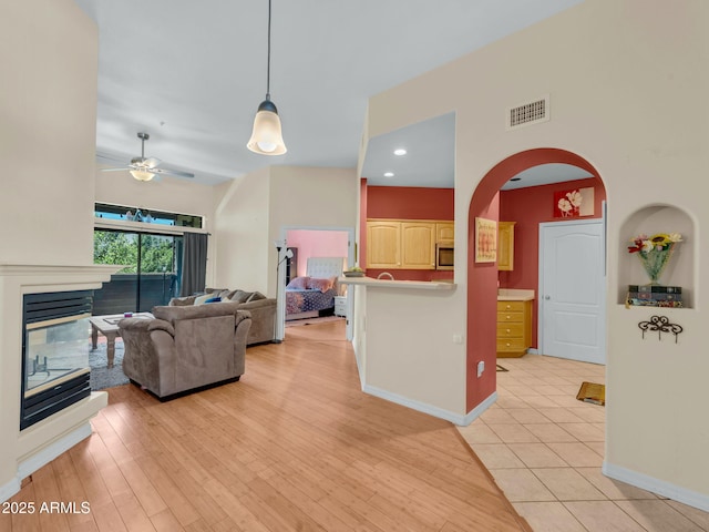 1401 N 4th St Unit 234, Flagstaff, AZ 86004 - living area with ceiling fan, a multi sided fireplace, arched walkways, and light wood-style flooring